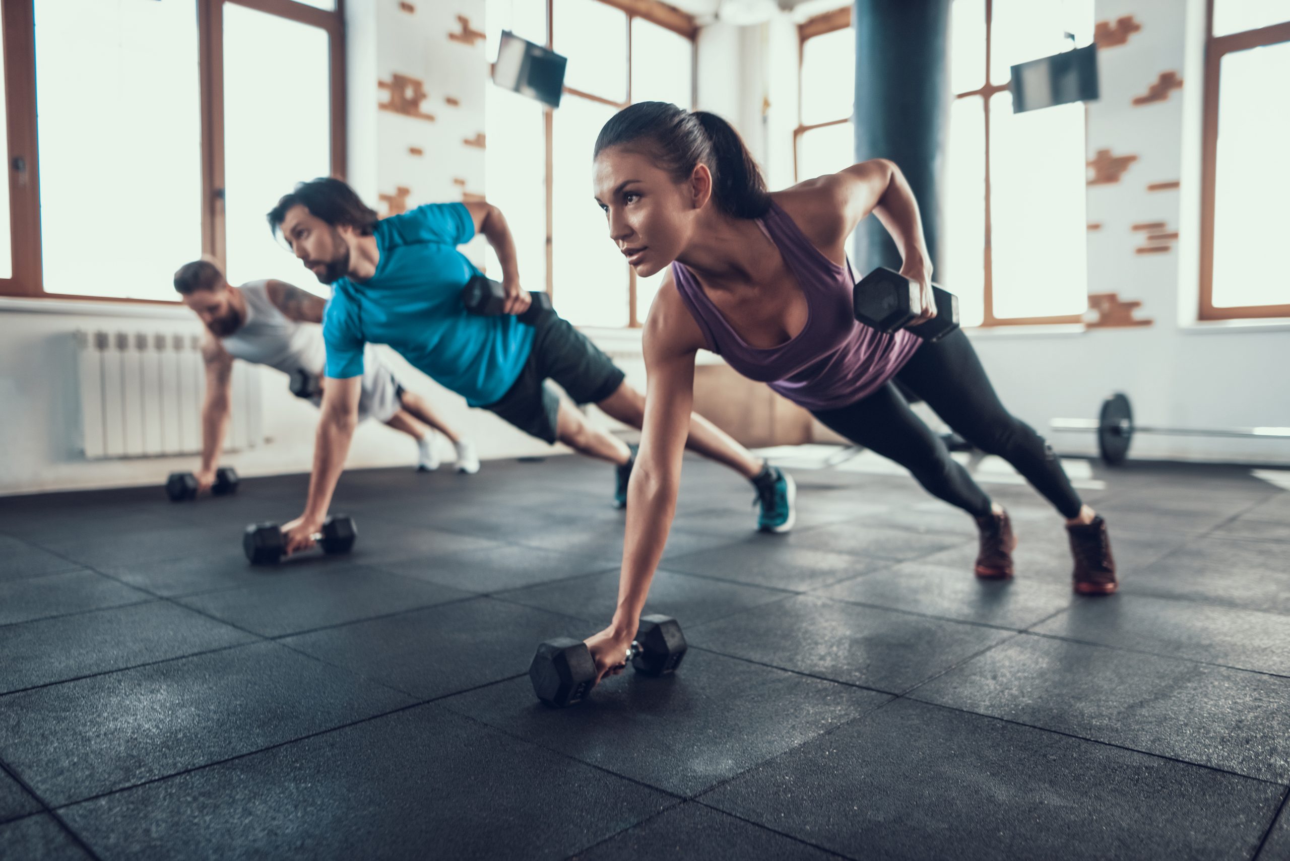 Athletes On The Floor. Dumbbell Lift With One Hand